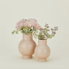 Two ceramic vases with flowers on a light beige background
