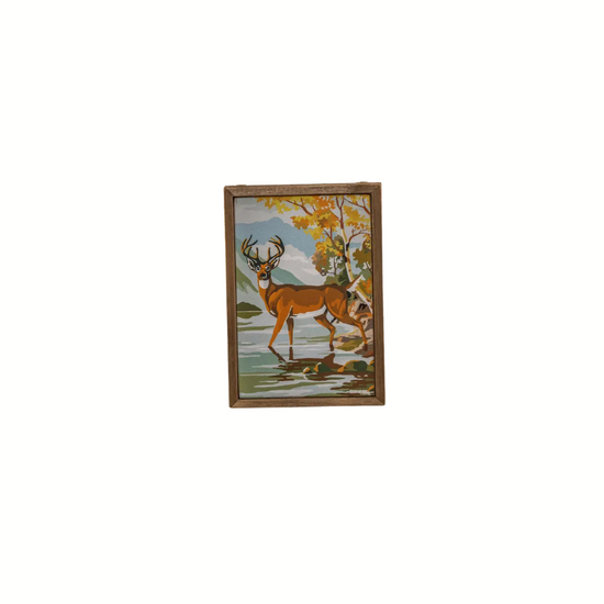 Framed artwork ornament of a deer in a natural setting on a white background
