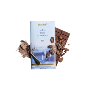 Malted milk chocolate bar with packaging and ingredients on a white background