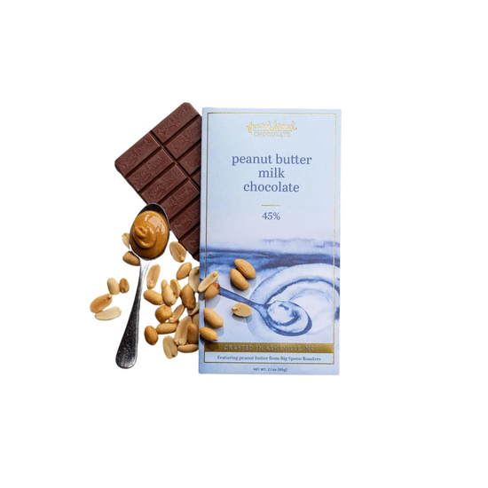 Peanut butter milk chocolate bar with a spoonful of peanut butter and peanuts on a white background